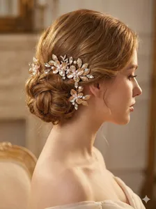 Close-up of golden floral hair pins with pearls and crystals worn by a bride in profile.