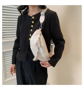 Professional model wearing a cream PU leather chest bag with decorative tassels and strap.