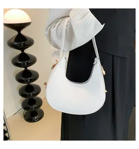 Close-up of white crocodile pattern crescent bag with elegant underarm strap design