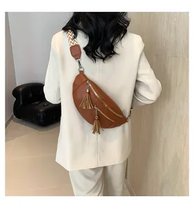 Back view of brown PU leather chest bag with tassels and patterned strap on model
