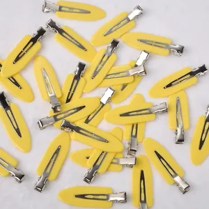 Close-up detail shot of multiple yellow creaseless hair clips on white plush background.