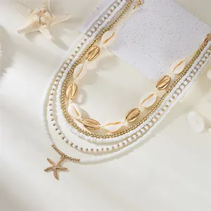 Detailed view of Bohemian 5-piece necklace set with white beads and golden shells.