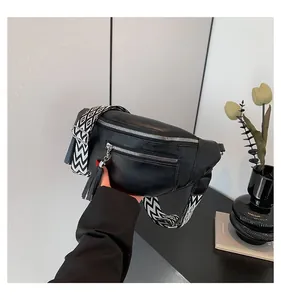 Detailed view of a black PU leather chest bag with a stylish patterned strap and tassel.