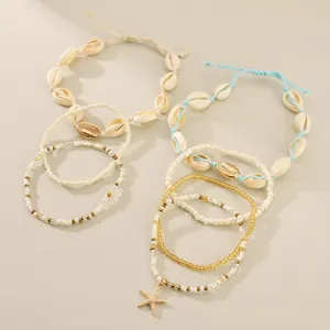 Detalle de tobilleras bohemias con cuentas, colgante de estrella de mar y caracolas.