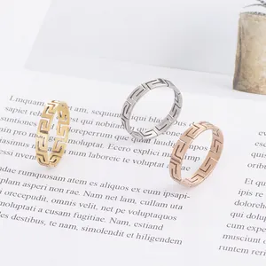 Three meander pattern titanium steel rings in gold, silver, and rose gold finishes