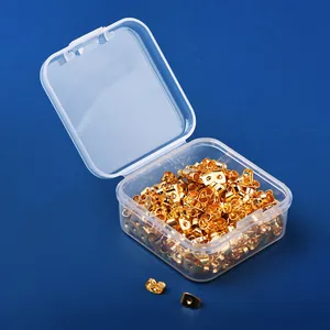 Macro view of gold butterfly earring backs stored in a clear plastic organizer box.