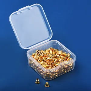 Detailed macro shot of bulk golden bullet-shaped earring backs in a clear storage box.