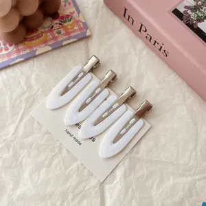 Close-up of four white crease-free hair clips organized on a minimalist display card