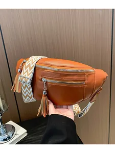 Stylish orange PU leather chest bag for women with wide patterned strap and tassels