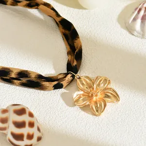 Primo piano dettagliato di una collana leopardata con un ciondolo a forma di fiore dorato