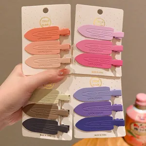 Detailed view of 12 matte gradient duckbill hair clips arranged on four cardstock displays