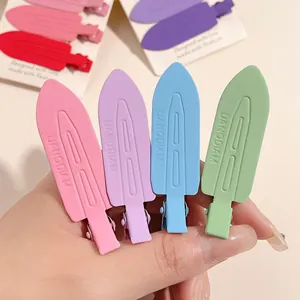 Detailed macro view of four matte finish pastel colored seamless duckbill hair clips