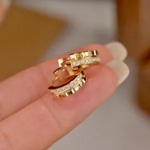 Detailed macro view of gold block hoop earrings featuring elegant shimmering rhinestones