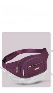 Close-up of a purple quilted multi-layer fanny pack featuring gold zippers and feathers