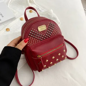 Mini sac à dos chic en cuir PU rouge avec motifs à rivets et finitions dorées élégant.