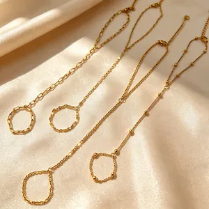 Close-up of gold-plated stainless steel hand back chains with various patterns on silk.