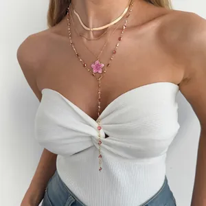 Mannequin portant un collier doré multicouche avec un pendentif fleur rose et perles