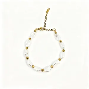 Close-up showing textured irregular baroque pearls and gold beads on a delicate chain.