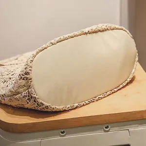 Detailansicht des verstärkten ovalen Bodens einer beigen Spitzen-Hohlstrandtasche