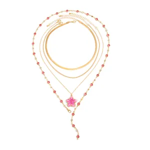 Vue détaillée de l'ensemble de colliers dorés avec pendentif fleur en émail rose