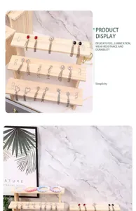 Primo piano di un espositore in legno a livelli che mostra varie paia di orecchini
