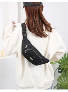 Detailed rear view of a black multi-layer women's fanny pack worn across a white sweatshirt