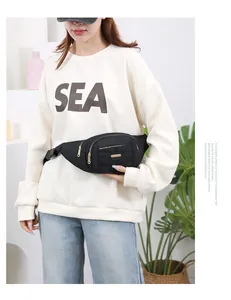 Detailed view of a fashionable black multi-layer waist bag worn on a casual sweatshirt outfit