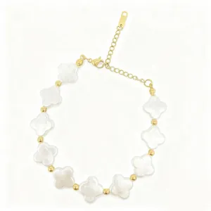 Detail view of baroque pearl bracelet featuring gold beads and white clover shapes