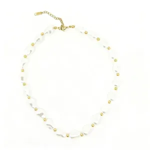Detail of irregular white Baroque pearls and small golden spacer beads jewelry piece