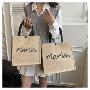 Detailed view of two sizes of jute tote bags with mama print and black handles