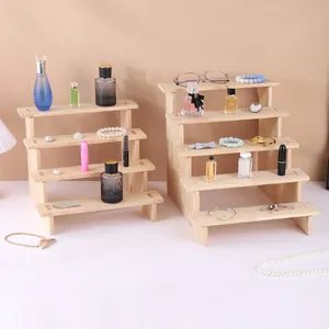 Due espositori in legno a gradini per organizzare profumi e gioielli su tavolo