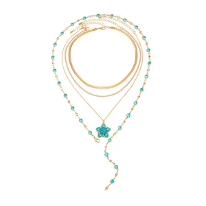 Vue détaillée du collier multi-rangs doré avec un pendentif fleur en émail bleu