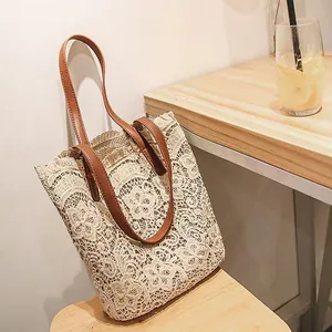 Detailaufnahme der beigen Spitzen-Strandtasche mit braunen Lederriemen