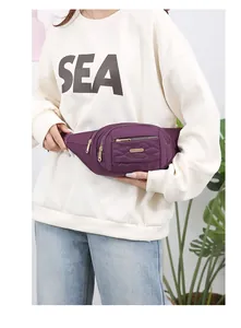 Detailed view of the purple quilted waist bag for women with multi-zipper design