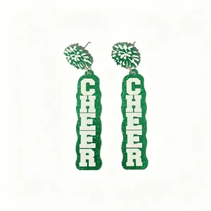 Close-up detail of green glitter acrylic cheerleading earrings with white bold text