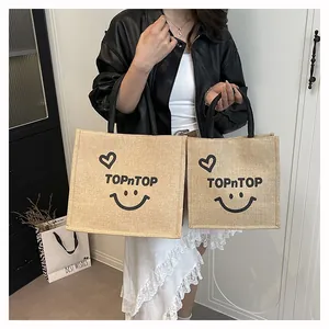 Visual comparison of large and small eco-friendly jute tote bags with smiley face print
