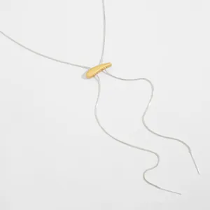 Gros plan d'un collier chaîne serpent réglable argenté avec pendentif croissant doré.
