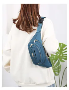 Multi-layer teal fanny pack worn as a stylish chest bag by a model.