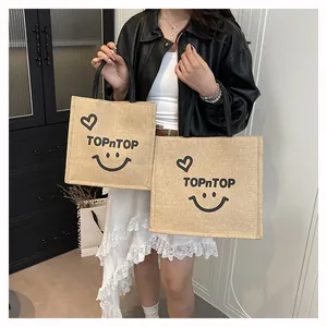 Detailed macro view showing the black TOPnTOP logo and heart-smile print on a jute bag