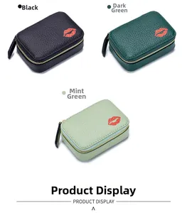 Drei stilvolle Mini-Ledertaschen in Schwarz, Grün und Minze mit besticktem rotem Lippendetail.