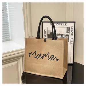 Jute tote bag with Mama print and black handles in a lifestyle setting