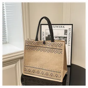 Spacious jute tote bag featuring stylish ethnic print and durable black handles for daily use