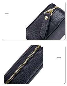 Makrodetail von goldenem Reißverschluss und schwarzem Leder an einer Kosmetiktasche.