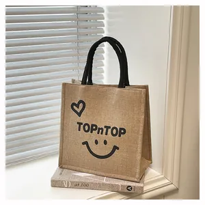Close-up detail of a printed jute tote bag featuring a heart and smiley face design