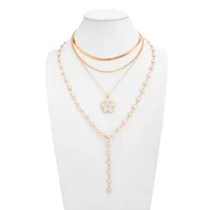 Vue détaillée de l'élégant collier doré à plusieurs couches avec fleur et perles