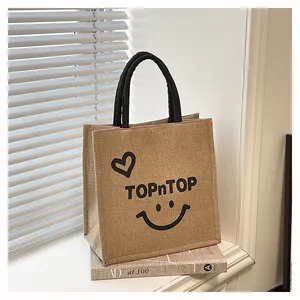 Close-up of a stylish burlap tote bag featuring TOPnTOP print and a cute heart pattern