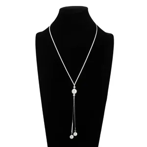Détail d'un collier chaîne serpent argenté minimaliste avec d'élégants pendentifs boules