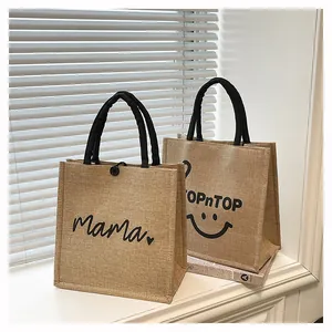 Detailed view of two eco-friendly jute shopping bags with Mama and smiley face prints