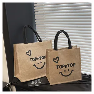 Eco-friendly natural jute tote bags in two sizes featuring a cheerful smiley face print