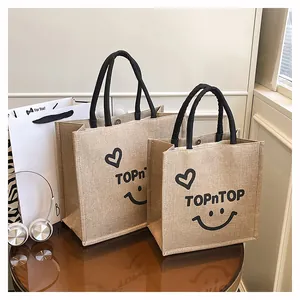 Detailed view of natural jute tote bags with heart and TOPnTOP smile print design